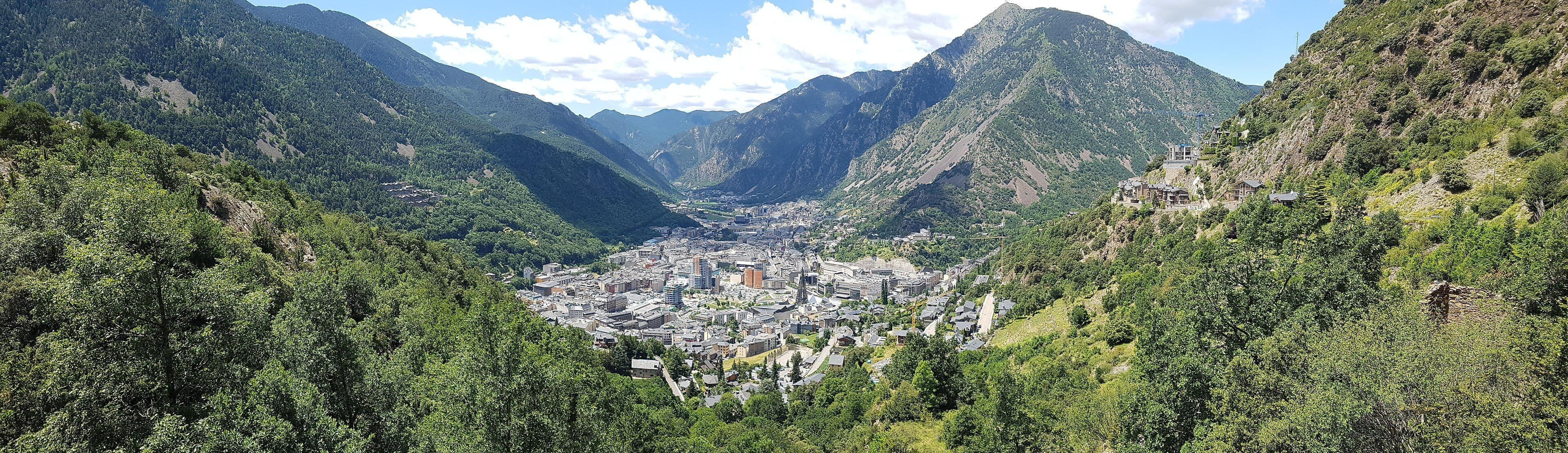 Andorra la Vella al fons de la vall, envoltada de muntanyes boscoses