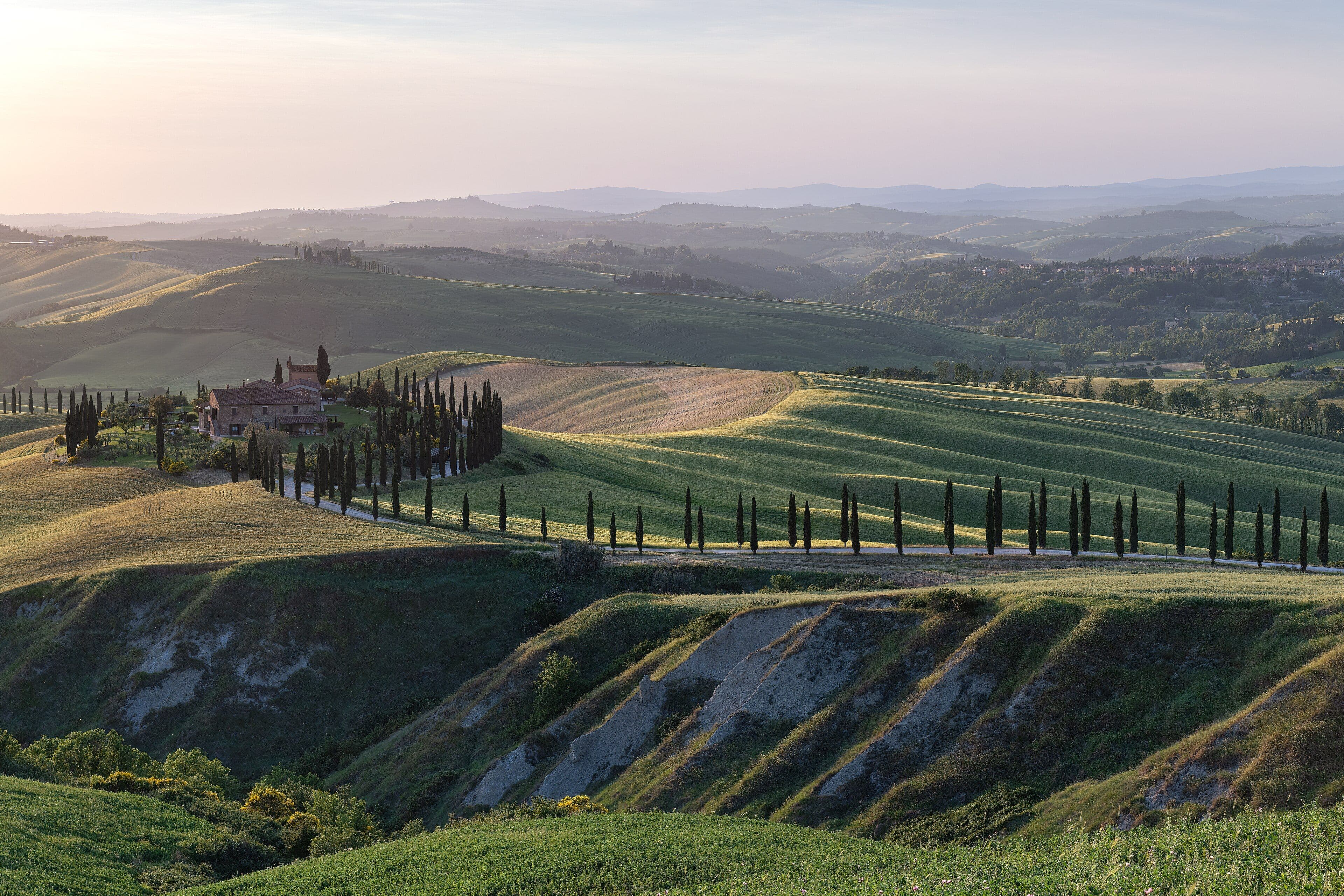 Colinas de la Toscana con un camino de cipreses al atardecer