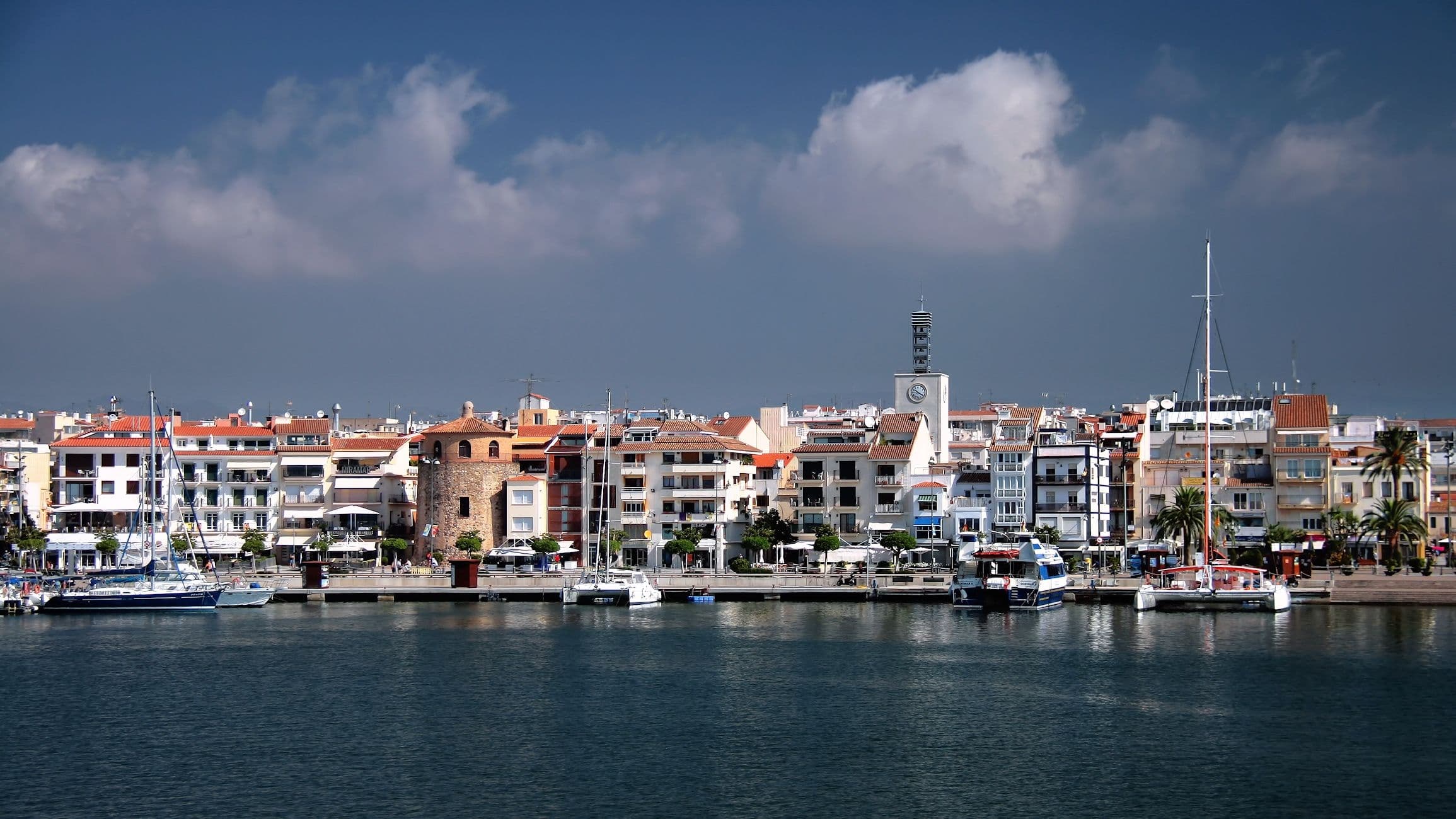El port pesquer de Cambrils, amb les barques amarrades i el poble al fons