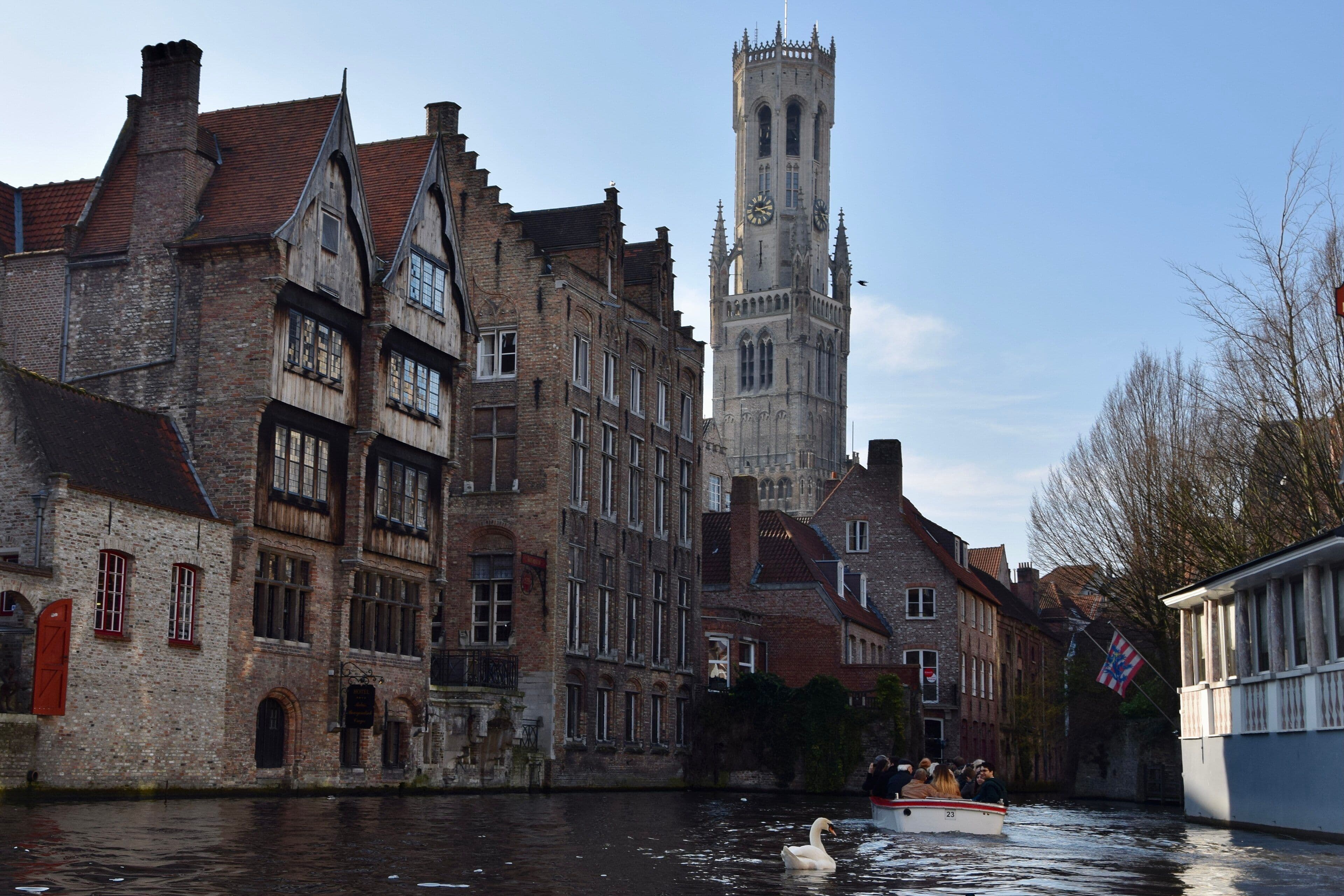 Canal de Brujas con el campanario al fondo y una barca de paseo